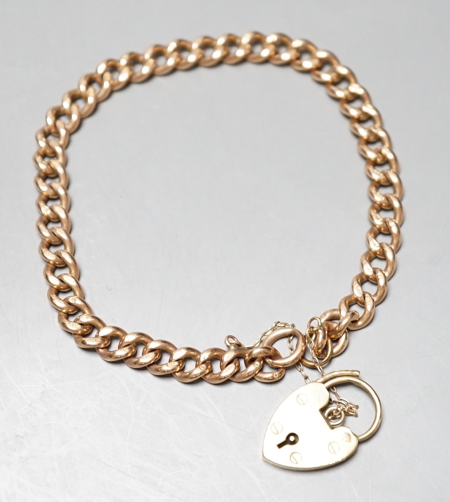 A 9ct gold curblink bracelet, with heart shaped padlock clasp, approx. 19cm